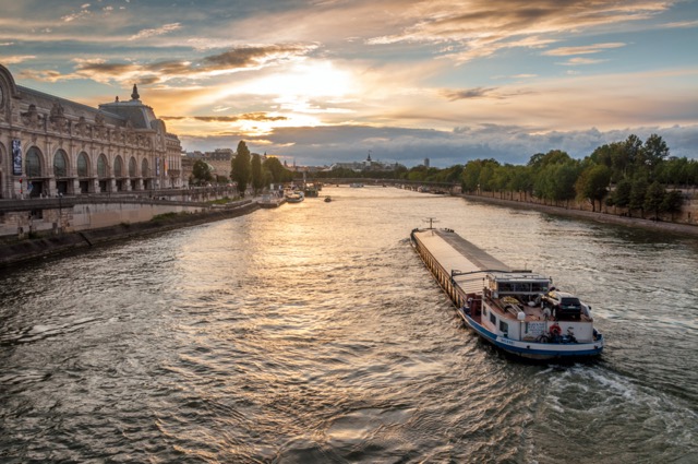 Transport fluvial électrique sur la Seine vue du Pont Royal au crépuscule à Paris